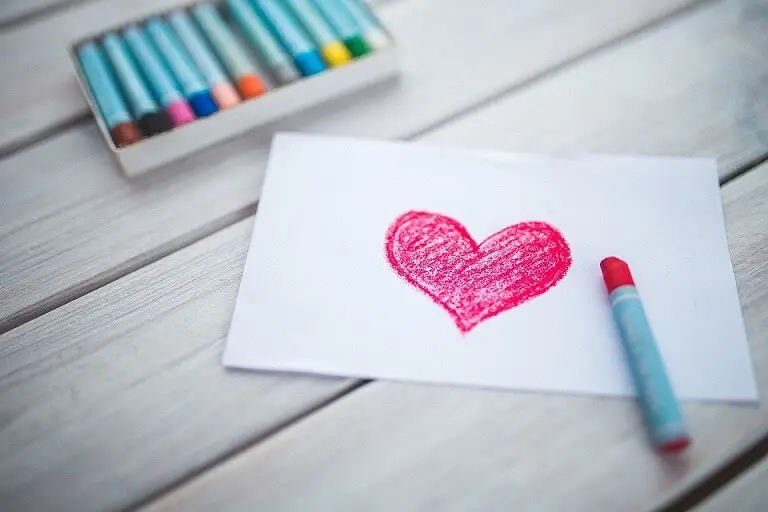 Money should never ruin a relationship but it does. Colouring a read heart on white paper with crayons.
