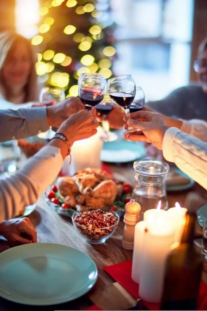 A lady making Christmas dinner with a tree lit in the background,