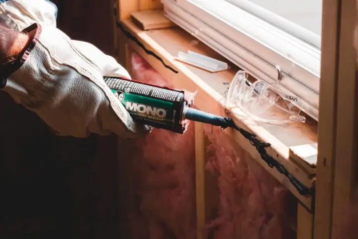 Caulking the windows to seal them shut to save money on utilities