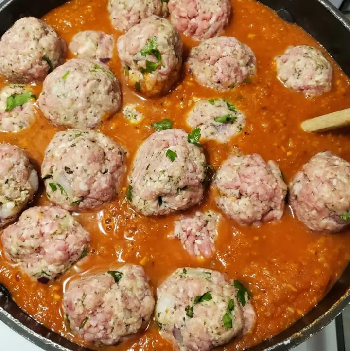 Raw Italian Meatballs put in Italian sauce