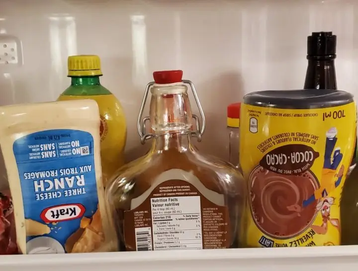 Bottles of Salad Dressing Turned upside down in the side of the refrigerator door to get to the last drop