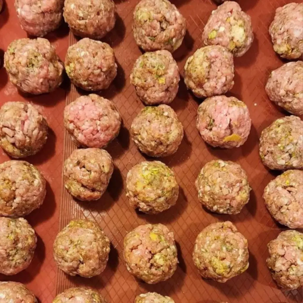 Line 60 mini meatballs on parchment paper to bake in the oven