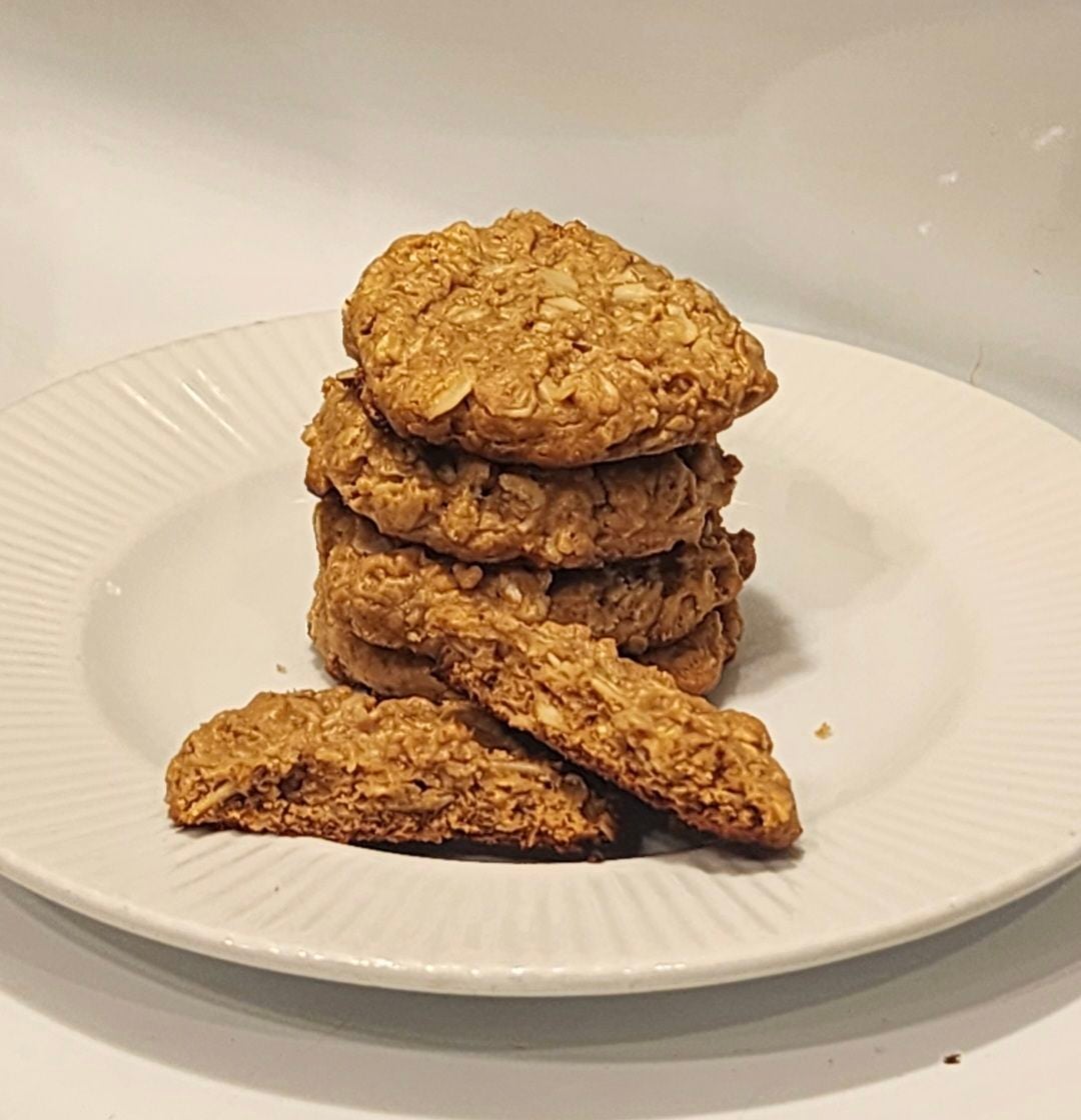 Stack of homemade peanut butter oatmeal cookies with broken pieces showing the oat-filled middle